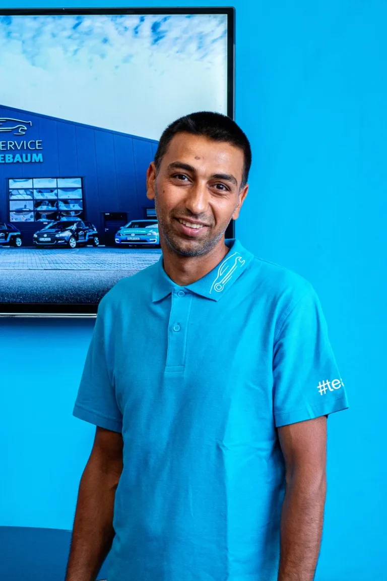 Mitarbeiter von Auto-Service Grönnebaum im blauen Firmenpolo im Empfangsbereich